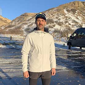 Tyson Yanchycki standing on an icy lake on a sunny day.
