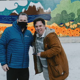 steven and friend are holding each others arms and smiling to the camera.